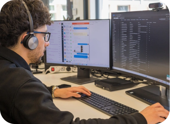 Mask group (4) Man focused on computer screens in a security operations center, representing 24/7 cybersecurity monitoring